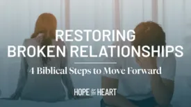A man and woman sit on opposite sides of a bed, both turned away from each other, appearing upset. Overlaid text reads: ‘Restoring Broken Relationships – 4 Biblical Steps to Move Forward.’ The Hope for the Heart logo appears at the bottom.