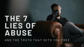 A man sits slouched on a leather armchair with his hand covering part of his face, appearing distressed. Text on the image reads: ‘The 7 Lies of Abuse’ and ‘And the Truth That Sets You Free.’