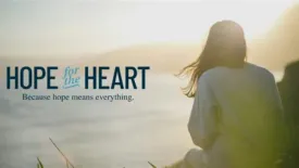 A person sits near the edge of a body of water at sunset, looking toward the glowing horizon. Text on the image reads: ‘Hope for the Heart’ with the tagline ‘Because hope means everything.’